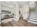 Inviting entryway with hardwood floors, white walls, staircase, and office space through glass French doors at 4148 Alexander View Dr, Charlotte, NC 28226