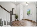 Bright foyer with hardwood floors, white walls, gray trim, decorative art and a view of the front door at 4148 Alexander View Dr, Charlotte, NC 28226