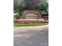 Stone community sign for Water's Edge surrounded by colorful flowers and greenery at 448 River Park Rd, Belmont, NC 28012