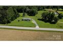 Aerial view of a charming home nestled on a sprawling green lot with mature trees at 4713 White Store Rd, Wingate, NC 28174