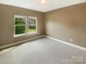 Bright, unfurnished bedroom with neutral carpet, a large window, and view to the outside at 5003 Tremont Dr, Indian Trail, NC 28079
