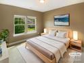 Cozy staged bedroom with natural light and a calm ambiance, next to a large window with green views at 5003 Tremont Dr, Indian Trail, NC 28079