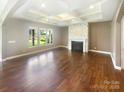 Spacious living room with hardwood floors, fireplace, and bright windows overlooking the backyard at 5003 Tremont Dr, Indian Trail, NC 28079