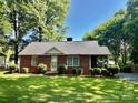 Charming brick house with mature landscaping, providing a welcoming curb appeal at 5722 Oak Dr, Charlotte, NC 28216