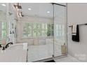 Luxurious primary bathroom with a glass-enclosed shower, soaking tub, and elegant marble finishes at 615 N Oak Dr, Huntersville, NC 28078