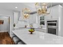 Bright kitchen featuring white cabinets, stainless appliances, a large island, and stylish gold pendant lighting at 615 N Oak Dr, Huntersville, NC 28078