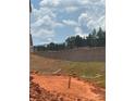 Graded lot ready for landscaping next to the side of a new home under construction with a privacy wall on the property line at 7008 Jerimoth Dr, Charlotte, NC 28215