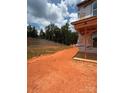 Graded lot ready for landscaping next to the side of a new home under construction with a privacy wall on the property line at 7008 Jerimoth Dr, Charlotte, NC 28215
