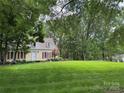 Traditional-style home featuring a lush green lawn and mature trees, providing shade and enhancing its curb appeal at 7137 Sythe Ct, Charlotte, NC 28226