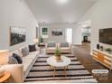 Bright, staged living room with modern furniture, neutral tones, and wood-look flooring, offering a welcoming atmosphere at 8219 Pozzi Rd, Charlotte, NC 28216