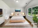 Staged main bedroom features a plush bed, modern decor, ample natural light, and stylish accents at 8219 Pozzi Rd, Charlotte, NC 28216