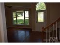 Inviting foyer with hardwood floors, staircase, and natural light streaming through the large front windows at 9228 Old Barnette Pl, Huntersville, NC 28078