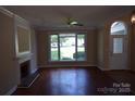 Inviting living room with hardwood floors, a fireplace, and a large window offering natural light at 9228 Old Barnette Pl, Huntersville, NC 28078
