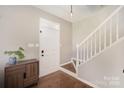 Bright entryway with hardwood floors, white trim, and staircase at 9808 Steed Ct, Charlotte, NC 28269
