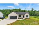 Beautiful modern farmhouse with a well-kept lawn and a dark-colored garage door at 1019 Null Rd, Lincolnton, NC 28092
