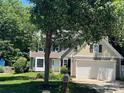 Beautiful home with a well-maintained lawn, mature trees, and a two-car garage at 11021 Scrimshaw Ln, Charlotte, NC 28215