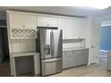 Bright kitchen featuring stainless steel refrigerator, granite countertops, and white cabinets at 11021 Scrimshaw Ln, Charlotte, NC 28215