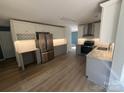 Spacious kitchen with stainless steel appliances, light countertops and backsplash, wood floors, and ample cabinet space at 11021 Scrimshaw Ln, Charlotte, NC 28215