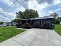 Charming home featuring a well-manicured lawn and landscaping with red roses at 111 Rose St, Mount Holly, NC 28120