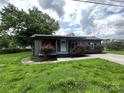 Charming home with covered porch and landscaping with red roses at 111 Rose St, Mount Holly, NC 28120