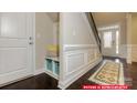 Stylish foyer with built-in bench, dark wood floors, and staircase at 112 Fordingbridge Ln, Mooresville, NC 28115