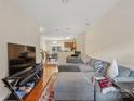 Spacious living room featuring hardwood floors, a comfortable sectional sofa, and natural light at 13909 Singleleaf Ln, Charlotte, NC 28278