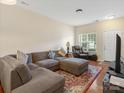 Comfortable living room featuring hardwood floors, a large sectional sofa, and ample natural light at 13909 Singleleaf Ln, Charlotte, NC 28278