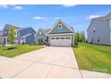 Charming blue home boasts a well-kept lawn and a convenient two-car garage at 1391 Links Crossing Dr, Monroe, NC 28112