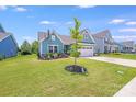 Beautiful home featuring manicured front lawn, stone accents, and a two-car garage at 1391 Links Crossing Dr, Monroe, NC 28112