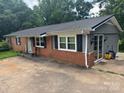 View of the exterior of a brick home with gray siding and black shutters showcasing outdoor charm at 2116 Dana Pl, Shelby, NC 28152