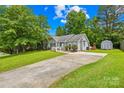Beautiful gray house with a well-manicured lawn, long driveway, and an outdoor storage shed at 2490 Hawk Ridge Dr, Gastonia, NC 28056