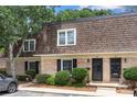 Charming townhouse exterior showcasing brick facade, manicured bushes, and a well-maintained brown shingle roof at 3500 Colony Rd # B, Charlotte, NC 28211
