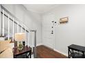 Bright foyer with white paneled door, coat rack and staircase featuring wood floors and gray banister at 3500 Colony Rd # B, Charlotte, NC 28211