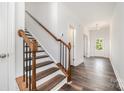 Inviting foyer showcasing hardwood floors, a staircase with wooden banister, and a view of the entryway at 5116 Izzo Ln, Charlotte, NC 28214