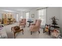 Bright living room featuring elegant furnishings, including wingback chairs and sheer curtains at 5640 Sharon Rd, Charlotte, NC 28210