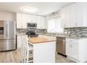 Modern kitchen with stainless steel appliances, white cabinetry, granite countertops, and a functional center island at 7416 Quail Ridge Dr, Charlotte, NC 28226