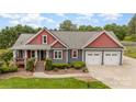 Charming two-story home with a manicured lawn, covered porch, and an attached two-car garage at 8993 Plank Rd, Norwood, NC 28128