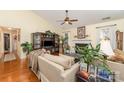 Bright living room with a vaulted ceiling, fireplace, hardwood floors, and large windows at 9011 Brad Ct, Matthews, NC 28104