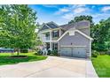 Charming two-story home featuring a two car garage, double stacked front porch, and mature shade tree at 112 E Heart Pine Ln, Statesville, NC 28677