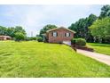 Brick home with a sprawling lawn and convenient drive-under garage at 1211 25Th Se St, Hickory, NC 28602