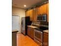 Well-equipped kitchen featuring stainless steel appliances, wooden cabinets, and granite countertops at 13116 Erwin Rd, Charlotte, NC 28273
