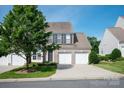Charming two-story home featuring a brick facade, two-car garage, and well-manicured lawn at 1498 Burrell Nw Ave, Concord, NC 28027
