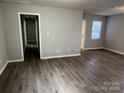 Spacious living room with hardwood floors, neutral paint, and easy access to other areas of the house at 1714 Maribel Ave, Charlotte, NC 28216