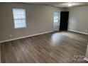 Bright living room featuring modern wood-look flooring, neutral paint, and ample natural light from a window at 1714 Maribel Ave, Charlotte, NC 28216