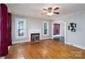 Spacious living room with hardwood floors, a decorative fireplace, and windows with natural light at 357 N Main St, Mount Pleasant, NC 28124