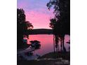 Picturesque view of the lake at sunset, showcasing the private dock and waterfront property at 369 Skyland Ct, Mount Gilead, NC 27306