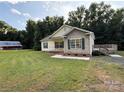 Quaint home with well-manicured lawn, mature trees, and a rustic outbuilding adding to the property's charm at 40287 Palmerville Rd, New London, NC 28127