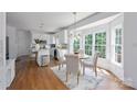 Eat-in kitchen with white cabinets, hardwood floors, stainless steel appliances and plenty of natural light at 5005 Chestnut Knoll Ln, Charlotte, NC 28269