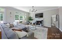 Bright living room with fireplace, large windows, hardwood floors, stylish rug, and comfortable seating at 5005 Chestnut Knoll Ln, Charlotte, NC 28269