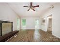 Open-concept living room with a decorative fireplace, light-colored walls, and hardwood floors at 5143 Delivau Dr, Charlotte, NC 28215